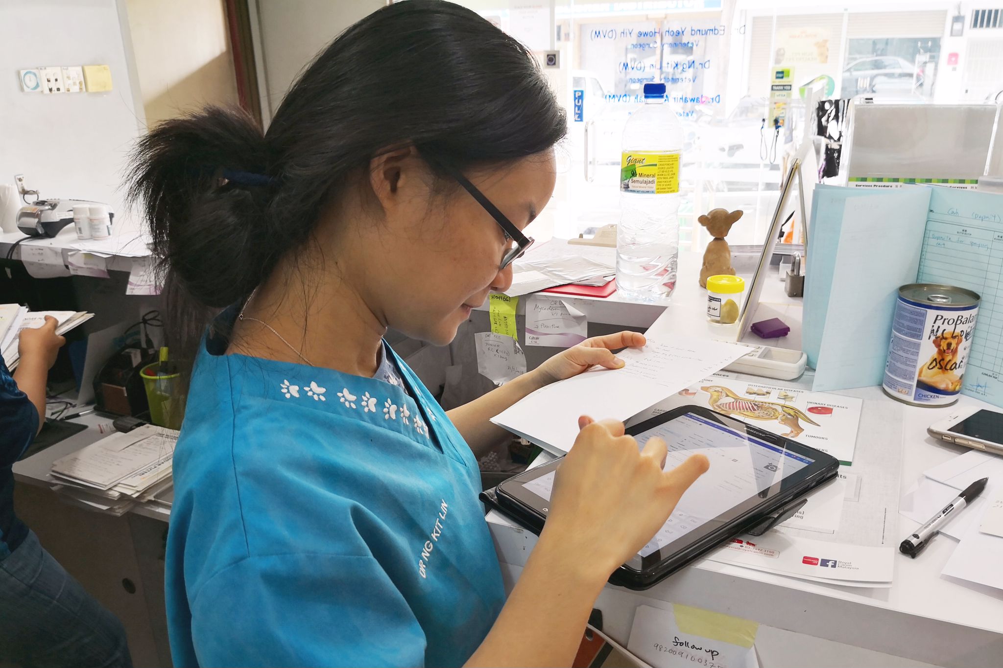 Dr. Ng is keying in details from her previous consultation to the tablet as part of the clinic